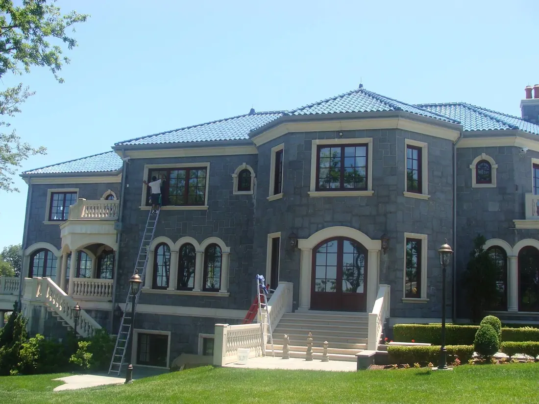 Large Long Island home with a freshly cleaned blue roof and Fabian’s ladder set up