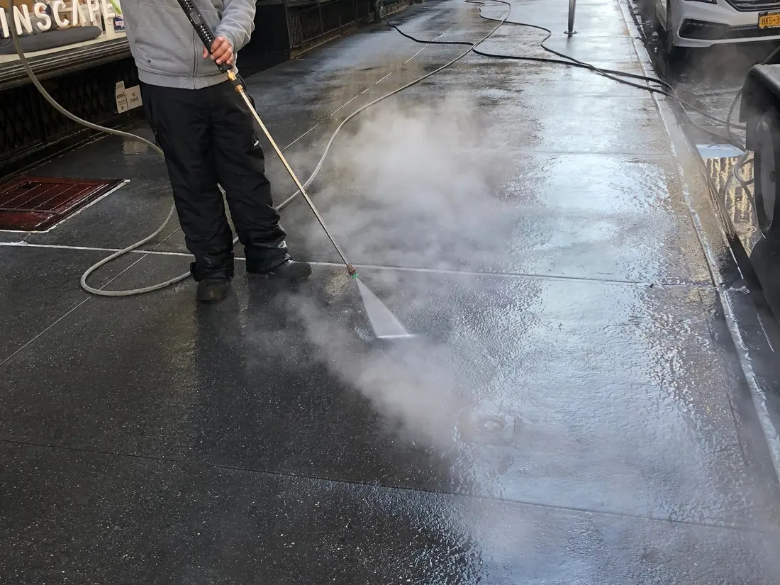Fabian’s technician power washing a city sidewalk